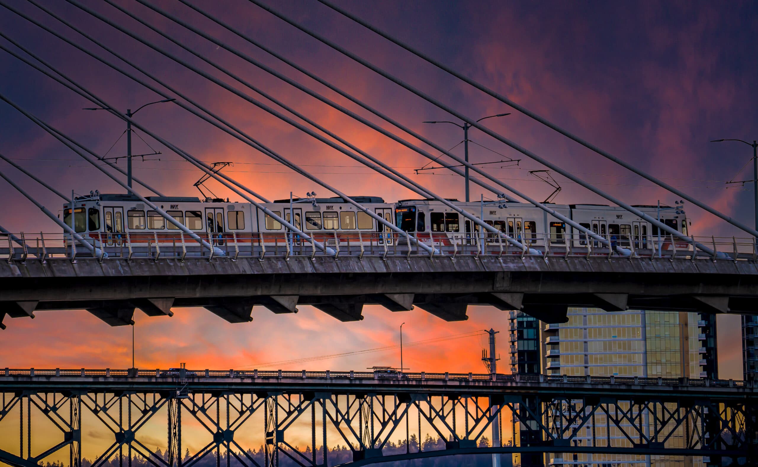 Holladay Park Plaza aerial light rail train at dusk.